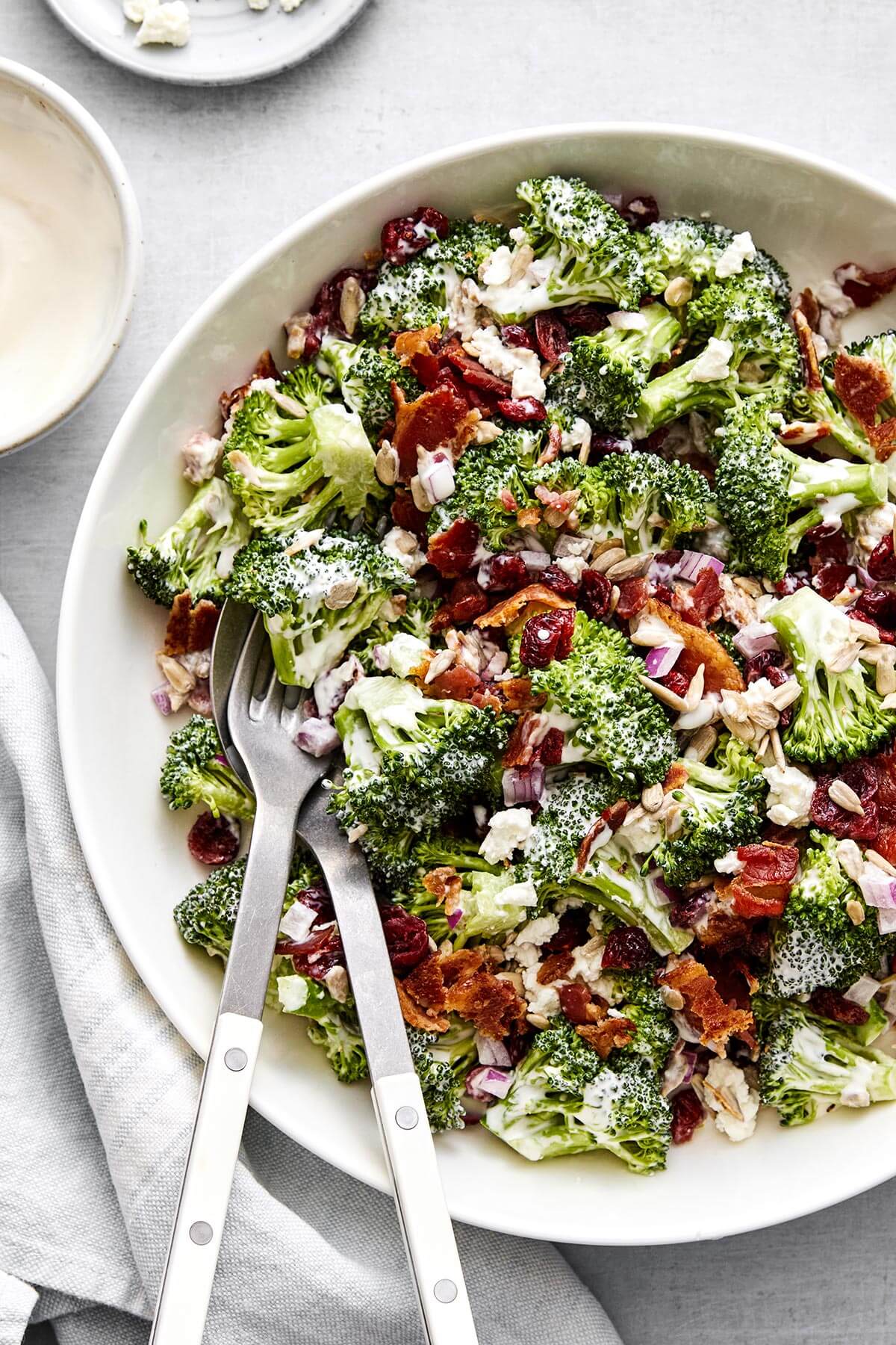 Everyone loves this broccoli salad recipe! With bacon, cranberries, and a creamy dressing, it's the perfect party side dish. A bowl of broccoli salad for a party side dish.