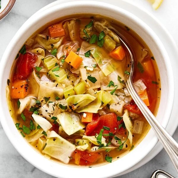 A white bowl of cabbage soup.