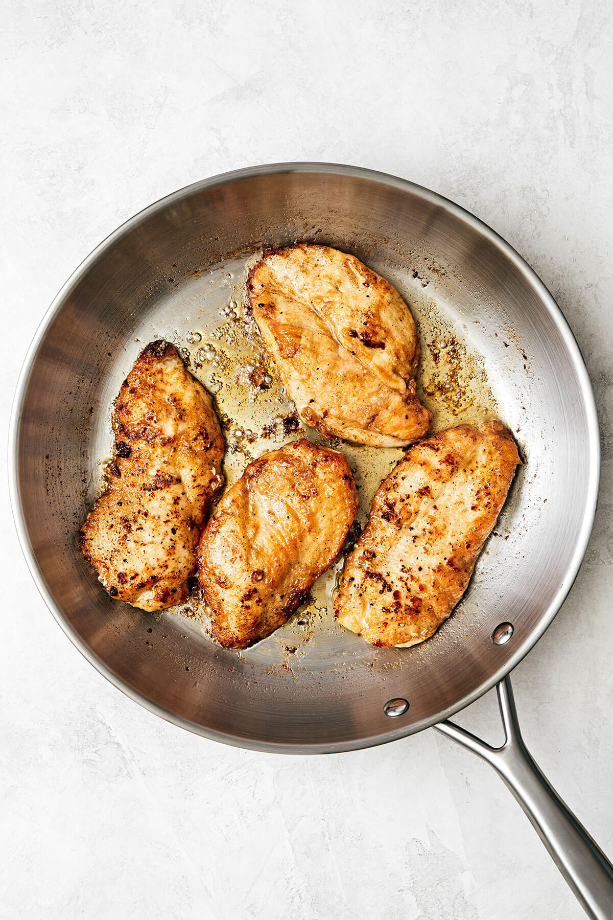 Chicken piccata is the best Italian-American dinner made with golden-crusted chicken breasts simmered in a lemon garlic wine sauce. Searing chicken for chicken piccata