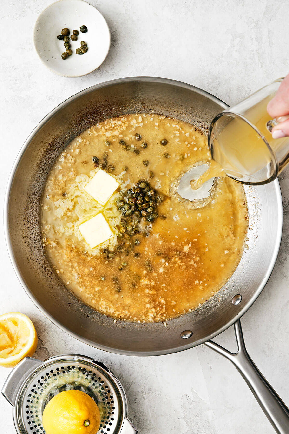 Chicken piccata is the best Italian-American dinner made with golden-crusted chicken breasts simmered in a lemon garlic wine sauce. Making wine sauce in pan for chicken piccata