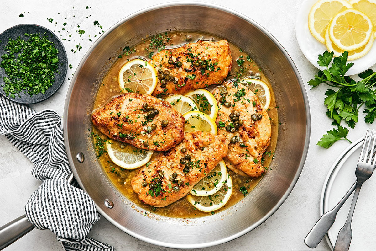 Chicken piccata is the best Italian-American dinner made with golden-crusted chicken breasts simmered in a lemon garlic wine sauce. A pan with chicken piccata