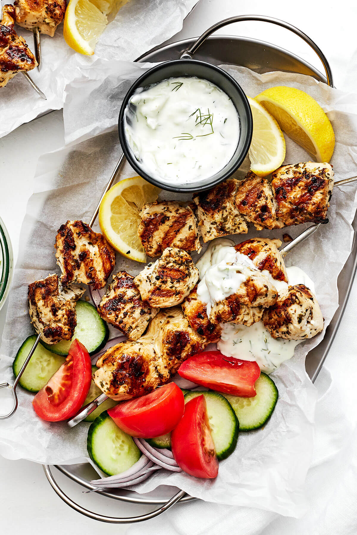 This Greek chicken souvlaki made with the best marinade will be everyone's favorite summer grilling recipe of the season! Grilled chicken souvlaki on a plate