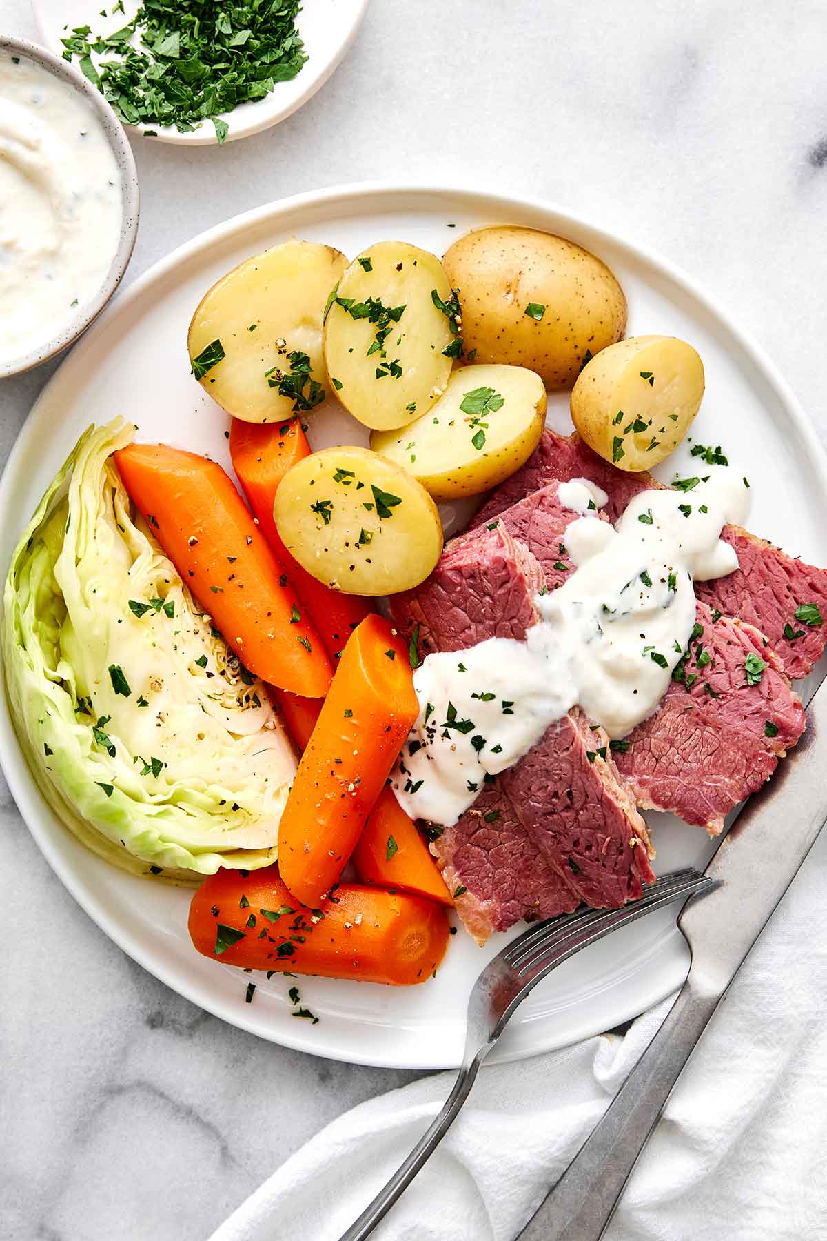 Celebrate St. Patrick's Day with the best corned beef and cabbage! Juicy brisket, creamy horseradish sauce, and hearty veggies. Corned beef and cabbage plate.