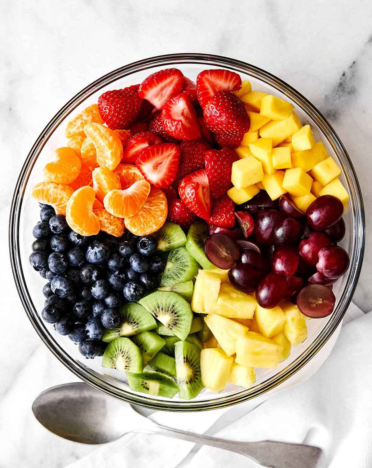 A crowd-favorite fruit salad for BBQs and potlucks! It's incredibly simple with juicy seasonal fruit tossed in a honey lime dressing. Step two of fruit salad: mix it all together.