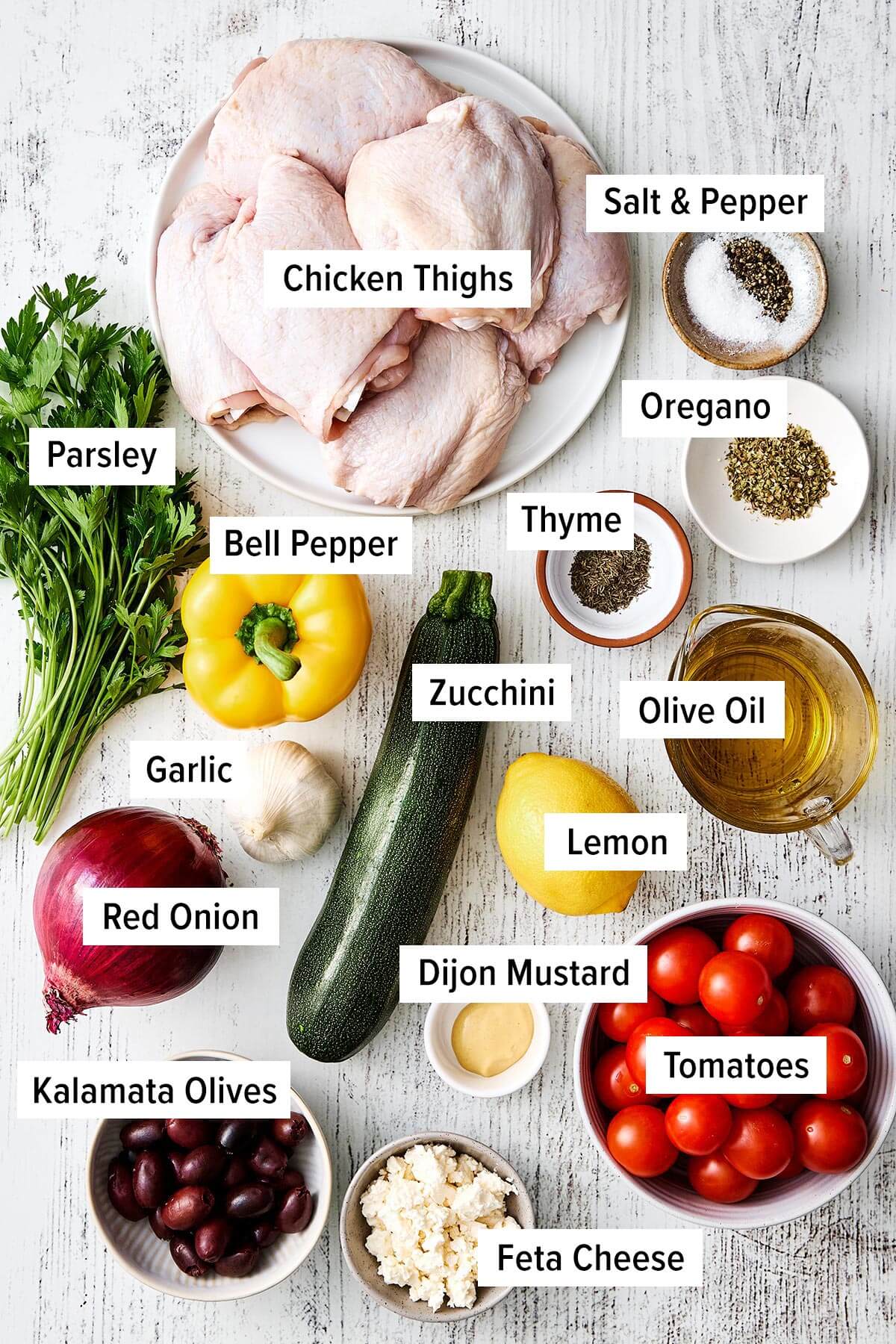 This Greek sheet pan chicken is an easy, all-in-one dinner recipe with juicy chicken thighs nestled around vibrant, Mediterranean vegetables. Ingredients for Greek sheet pan chicken.