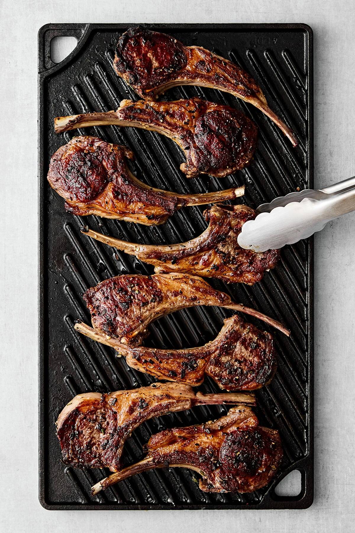 These garlic rosemary lamb chops come off the grill perfectly charred and tender every time—perfect for the holidays and grilling season! Grilling lamb chops on a grill.