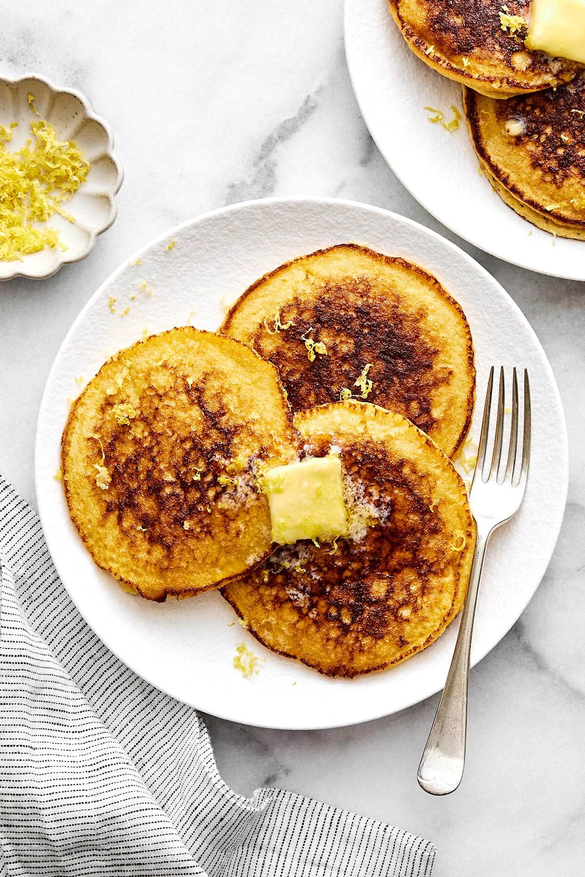These fluffy lemon ricotta protein pancakes are a sweet and delicious way to incorporate more protein into your breakfast routine! Lemon ricotta protein pancakes on a plate.