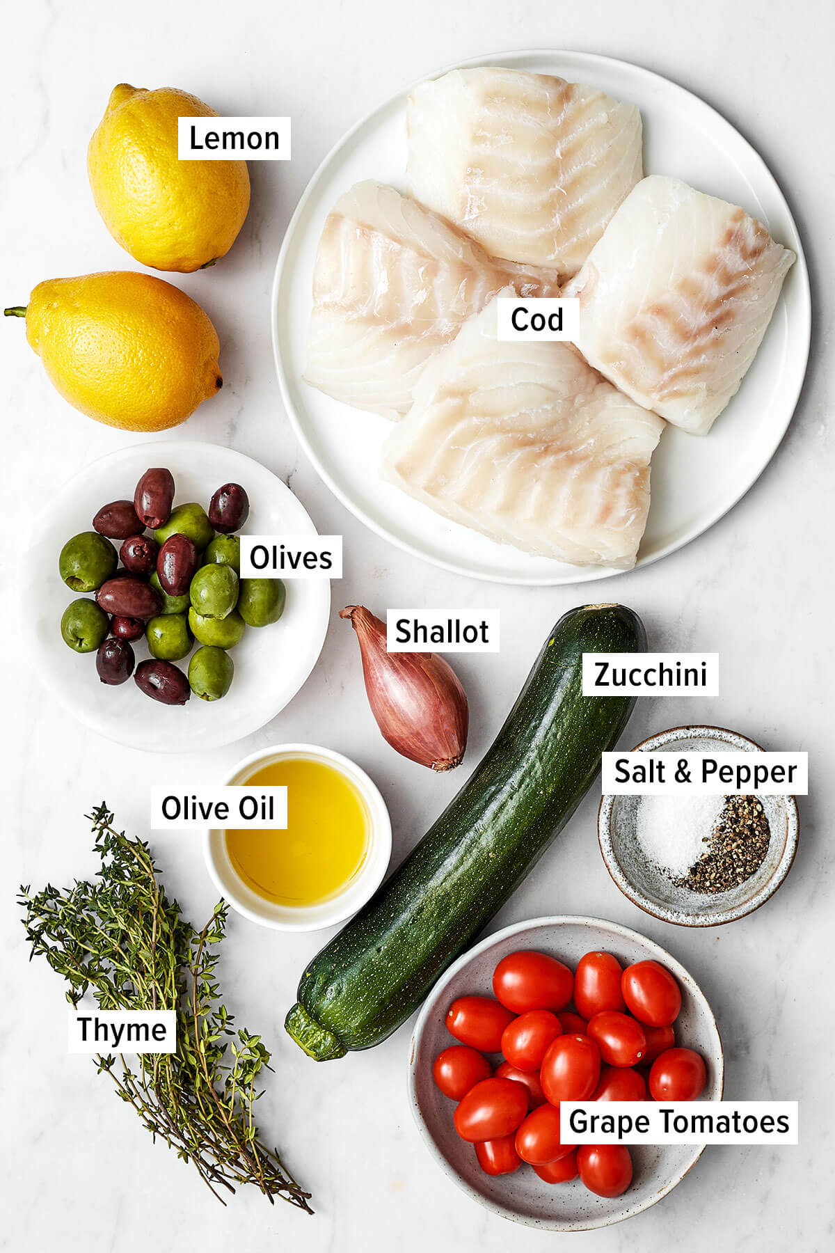 This Mediterranean cod en papillote is the most genius way to quickly achieve a simple, healthy, and super delicious dinner! Ingredients for fish en papillote on a table