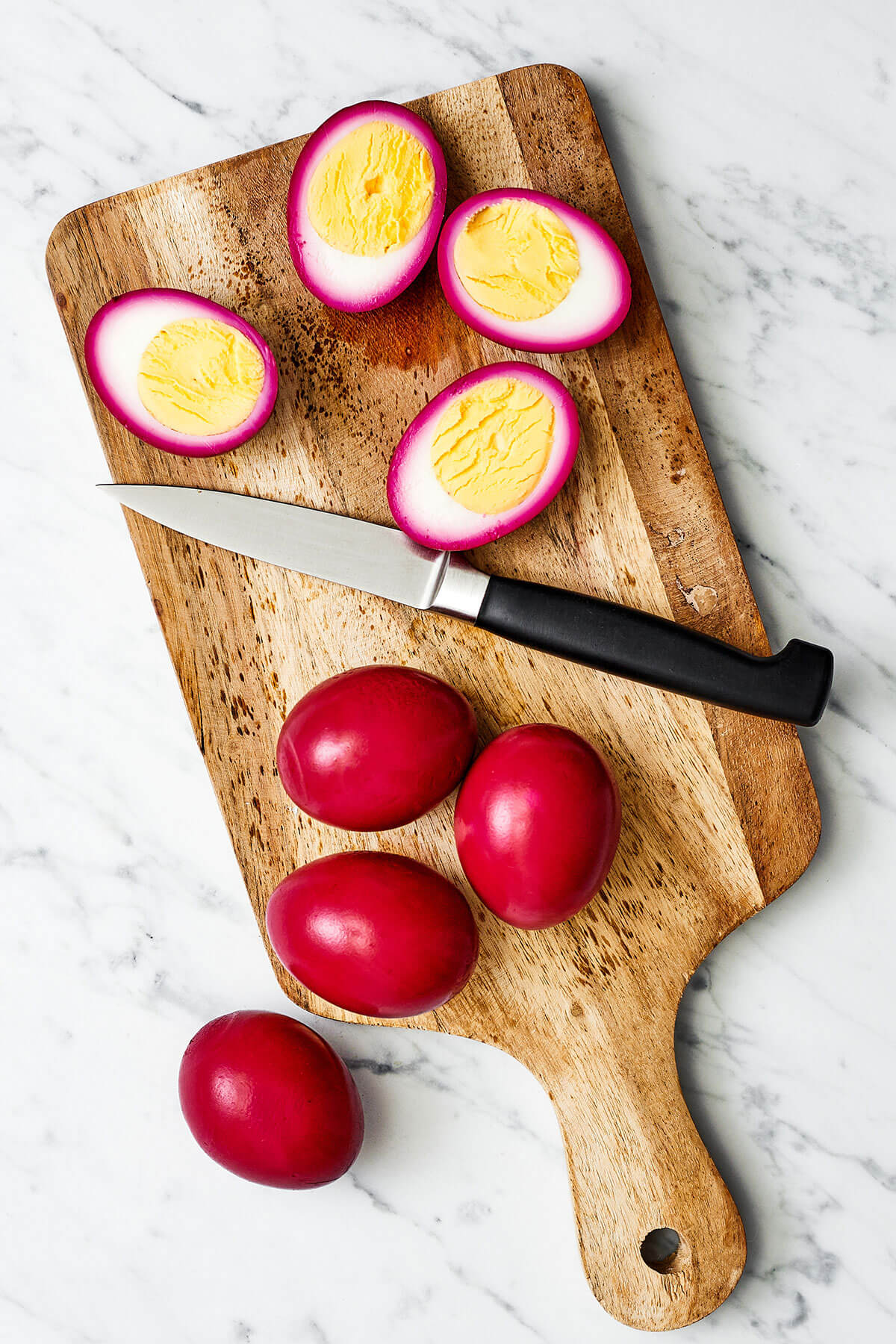Step up your appetizer game with beet pickled deviled eggs! They're stained to a beautiful red, taste delicious, and are perfect for Easter. Slicing beet pickled deviled eggs