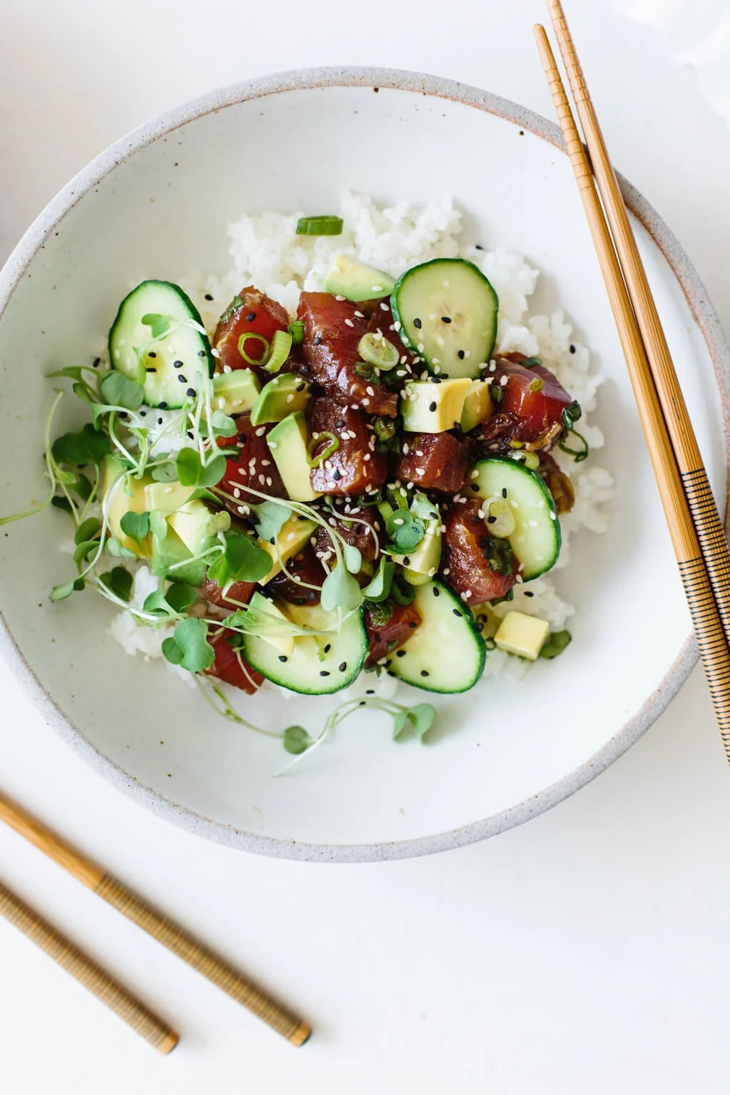 Ahi tuna poke in a white bowl with chopsticks.