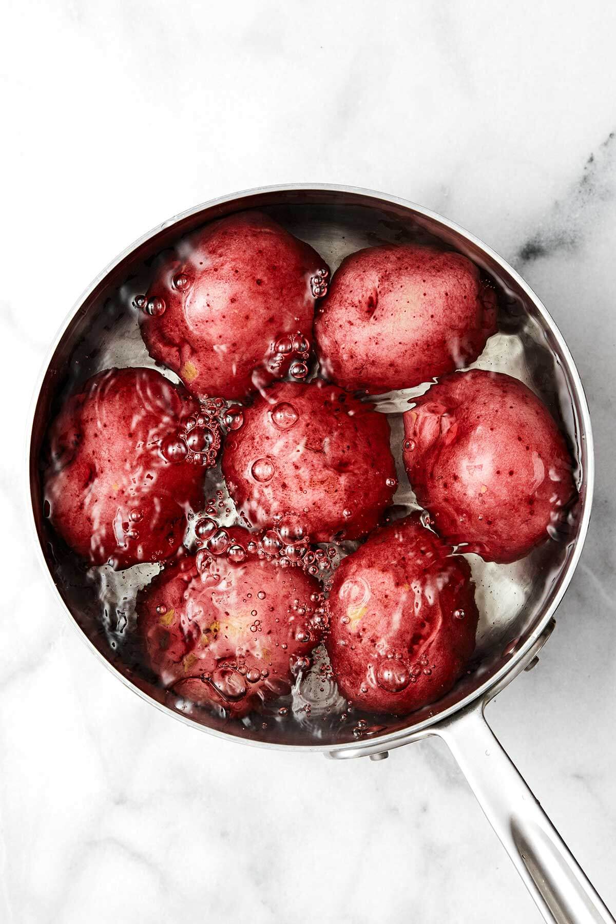 This classic potato salad is easy, flavorful, and loaded with texture. It's the perfect side dish for summer BBQ's, picnics, and dinner parties! Boiling red potatoes in a pot.