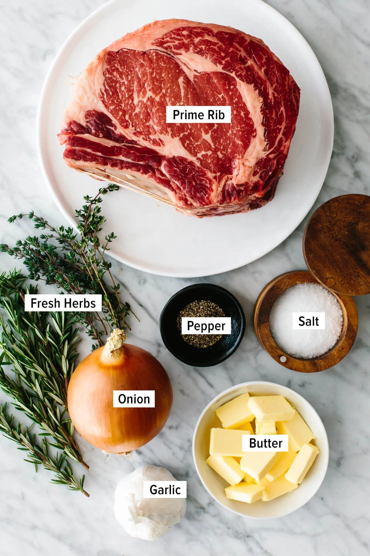 This is the best prime rib recipe with a garlic herb crust! The perfect holiday standing rib roast! Ingredients to make prime rib on a counter.