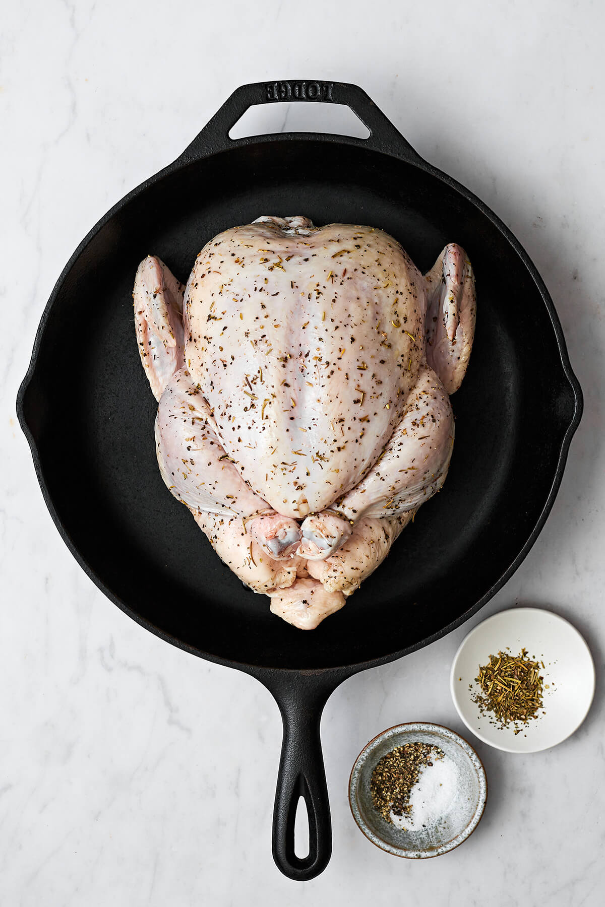 Learning how to roast chicken is the ultimate kitchen staple. It's easy to make, feeds a surplus, and can be served in dozens of ways! Seasoned whole roast chicken in a skillet