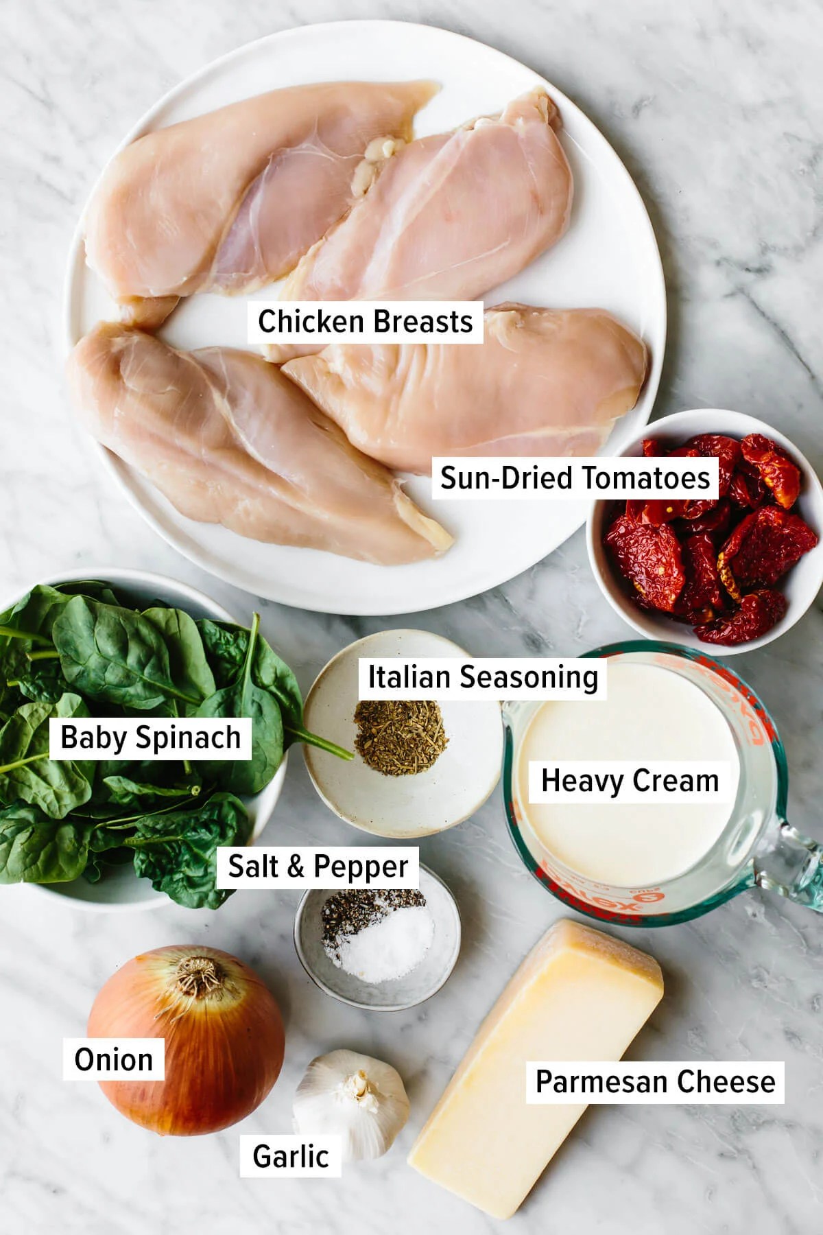 Steal hearts with this creamy tuscan chicken recipe! Seared Italian chicken simmers in a rich and creamy, spinach and sun-dried tomato sauce. Ingredients for tuscan chicken on a table